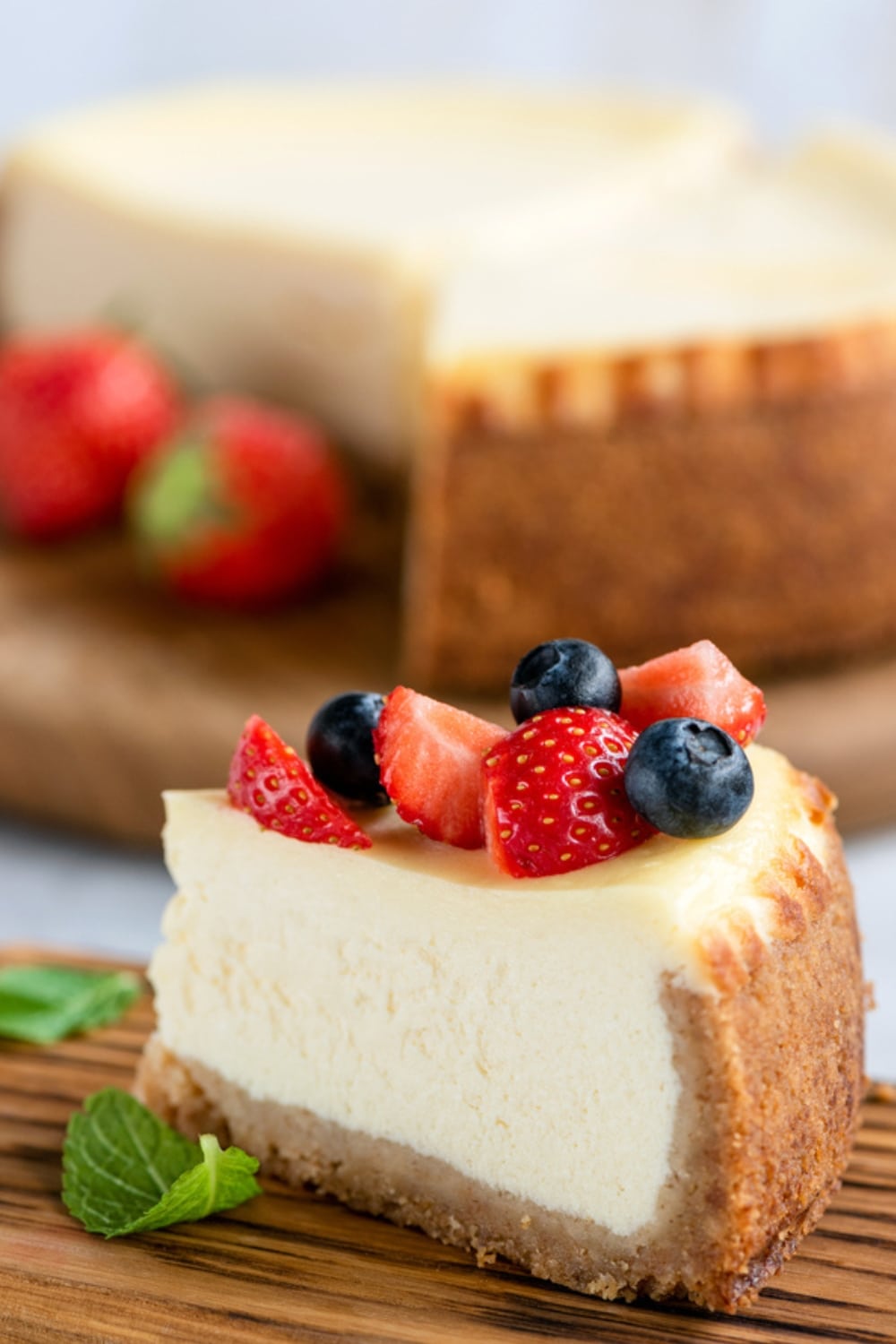 Creamy Thick Slice of New York Cheese Cake With Sliced Strawberries and Blueberries