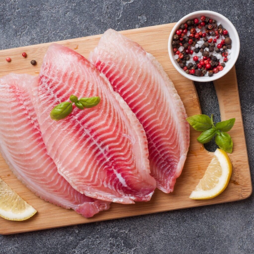 Sliced Fresh Tilapia Fillet on a Chopping Board