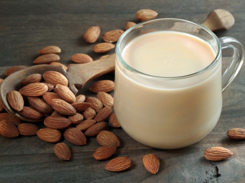 Almond Nuts, Wooden Spoon and Glass of Almond Milk