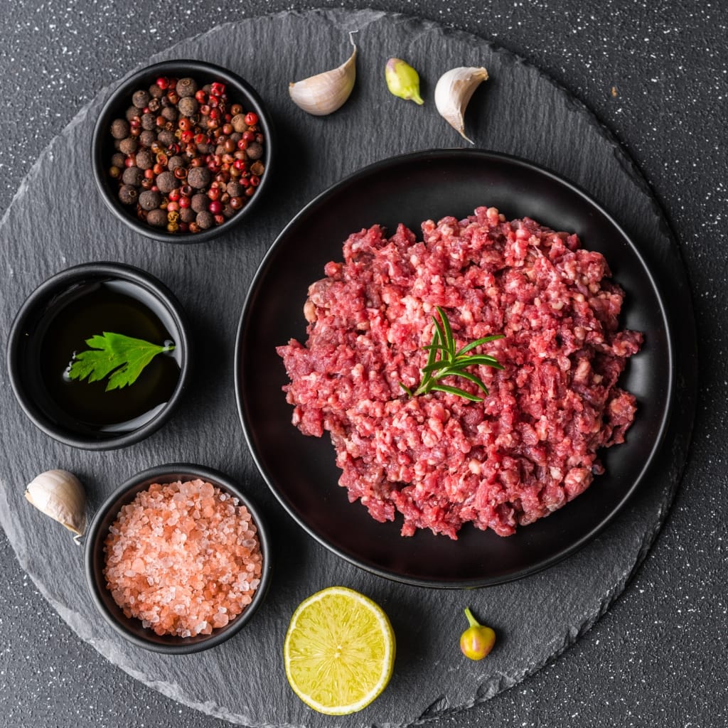Ground Beef with Seasonings on a Black Board