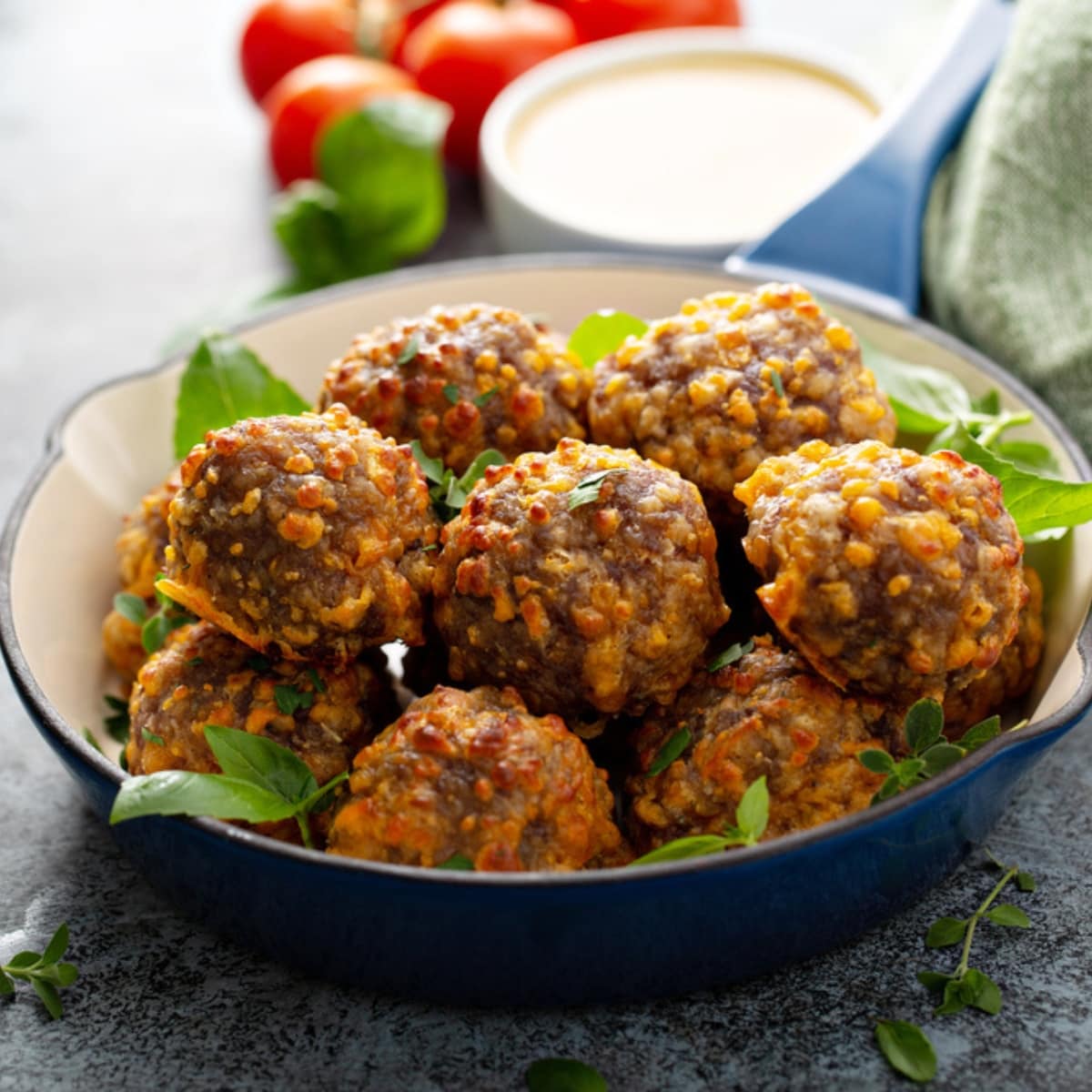 Cheesy Jimmy Dean Sausage Balls on a Skillet Garnished With Fresh Herbs