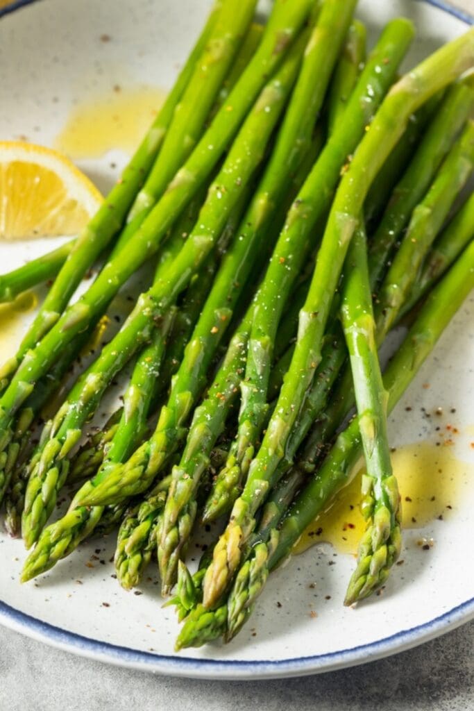 Steamed fresh asparagus with lemon wedges and seasonings