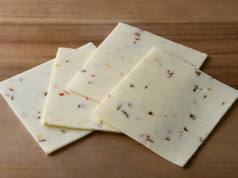 Four Monterey Jack Slice on a Wooden Cutting Board