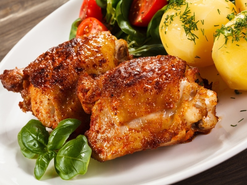 Oven Baked Chicken Thighs Served With Boiled Potatoes and Fresh Veggies and Herbs