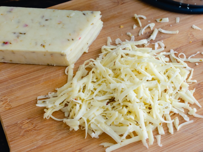 Grated Pepper Jack Cheese on a Wooden Cutting Board