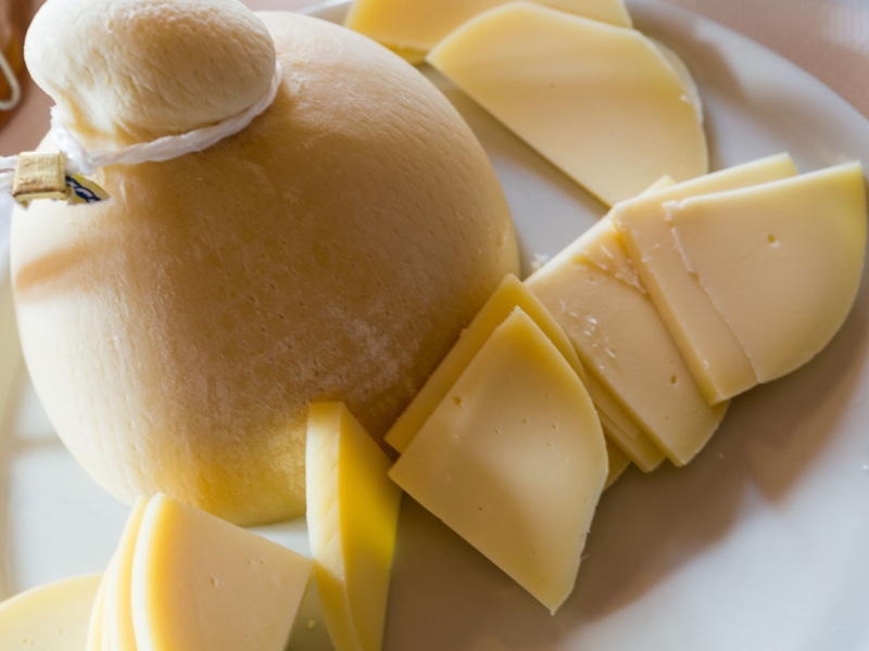 Whole and Slice Provolone Cheese on Table