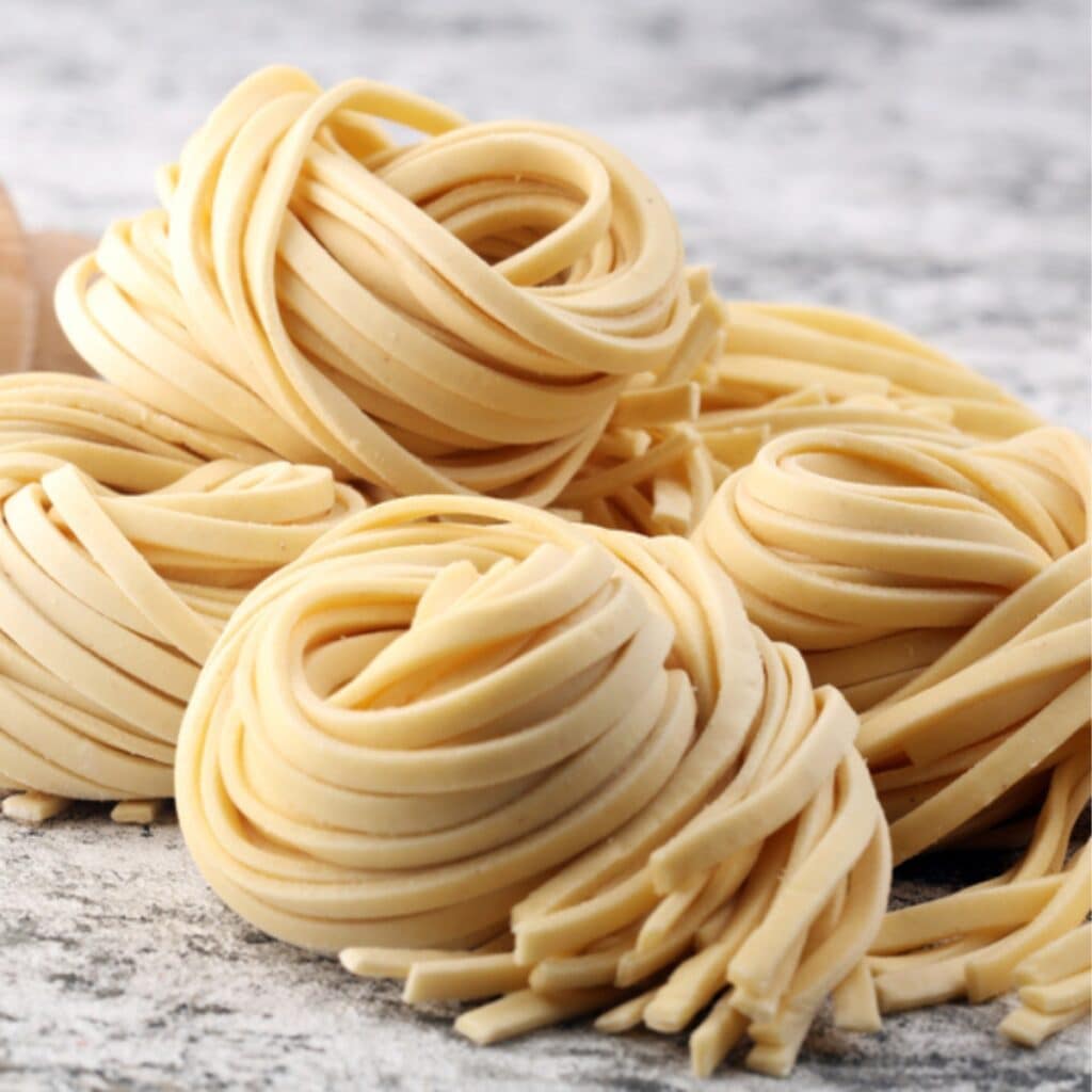 What Are Egg Noodles? (+ How To Make Them) featuring Nests of Homemade Egg Noodles