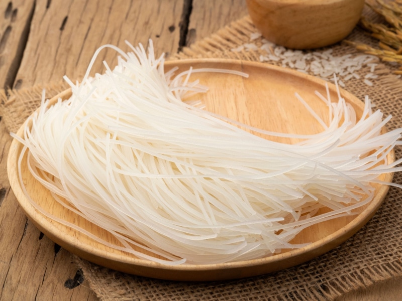 Raw Uncooked Rice Stick Noodles on a Wooden Tray