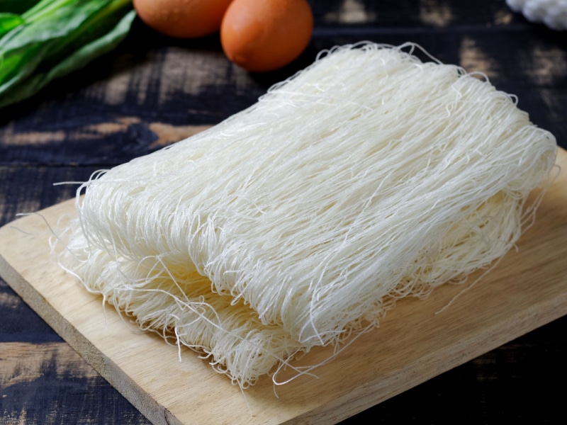 Raw Uncooked Rice Vermicelli on a Wooden Cutting Board
