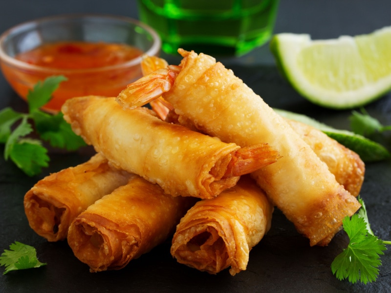 Deep Fried Shrimp Spring Rolls with Sauce and Parsley on a Stone Table