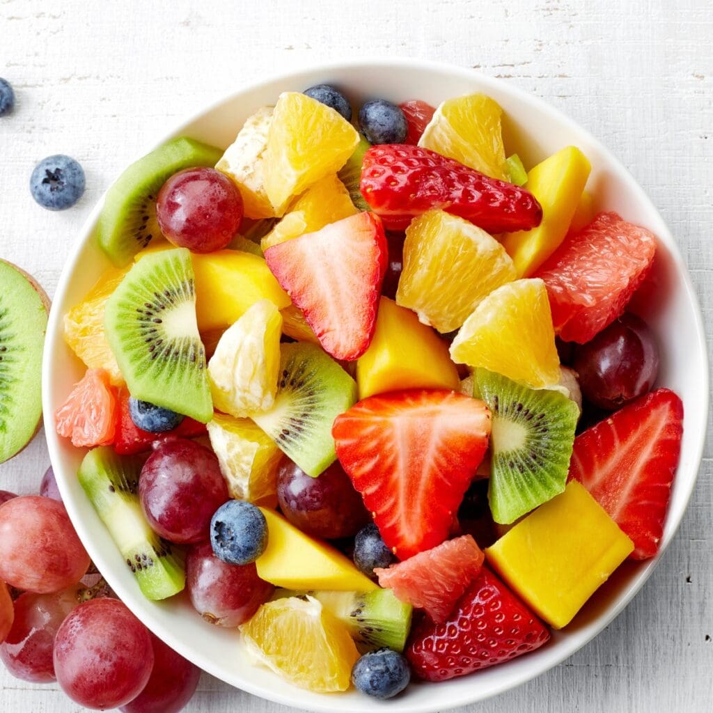 Bowl of Fruit Salad with Sliced Fresh Strawberries, Kiwis, Oranges, Grapes, Mangoes, and Grapefruit 