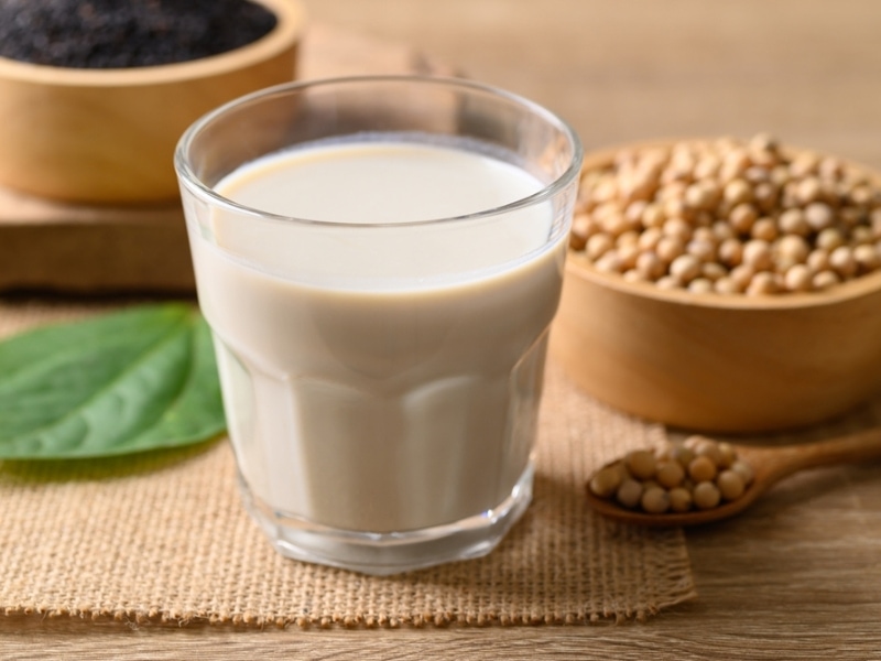 Soybeans in a Wooden Bowl and Spoon in the Background, Glass of Soy Milk