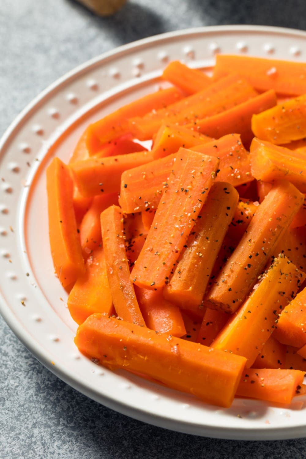 Steamed Carrots on a Plate Seasoned with Salt and Pepper