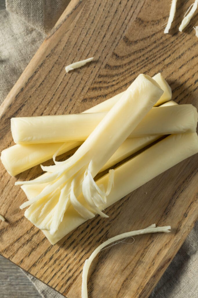 Healthy Organic String Cheese on a Wooden Cutting Board