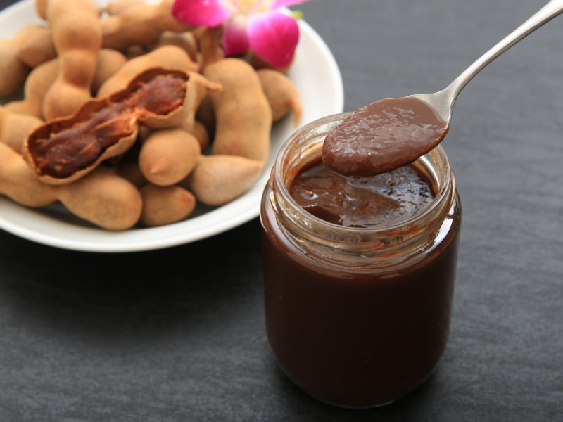 A Jar of Tamarind Paste and A Platter of Ripe Tamarinds