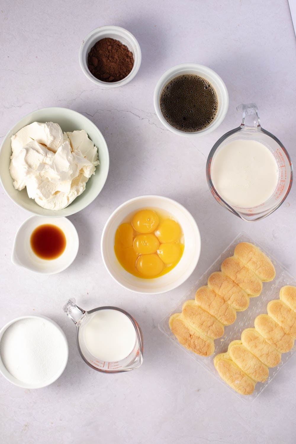 Tiramisu Ingredients - Mascaporne, Egg Yolks, Sugar, Milk, Whipped Cream, Vanilla, Ladyfingers, Coffee, Rum and Cocoa Powder