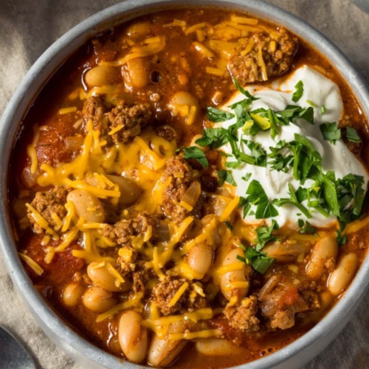 Savory Turkey Chili With Cheese, Sour Cream and Chopped Fresh Parsley