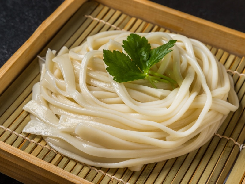 Udon Noodles on a Bamboo Tray Garnished with Parsley