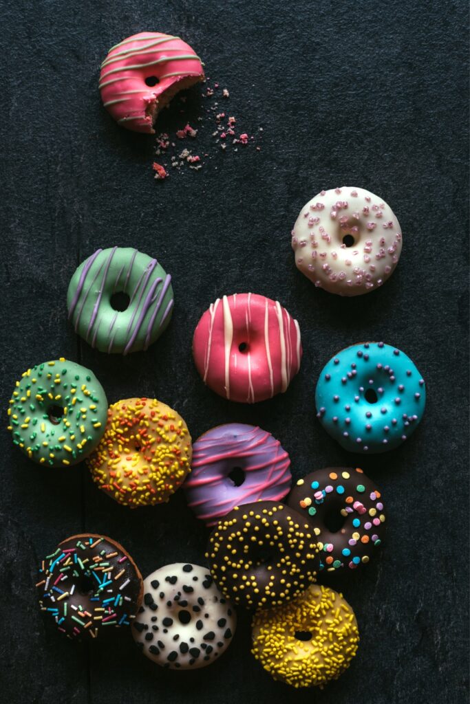 What Is a Baker's Dozen? (And Why?): Variety of Colorful Sweet Mini Baker's Dozen Donuts on a Black Background