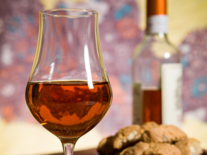 A Glass of Vin Santo Wine and  a Bowl of Cantucci Biscuits with a Bottle of Vin Santo Wine in the Background