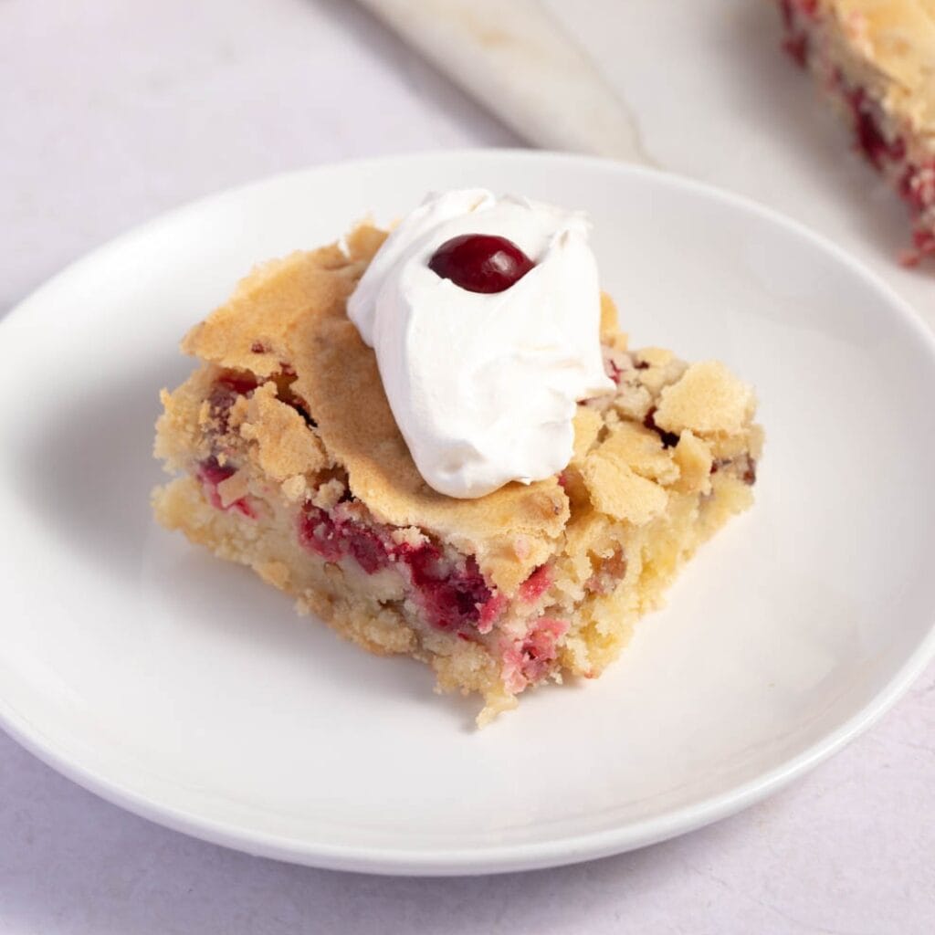 A Slice of Cranberry Christmas Cake with Whipped Cream