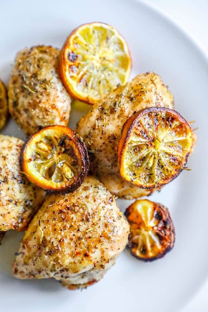 Air fryer cooked and seasoned chicken breast with lemon slices.