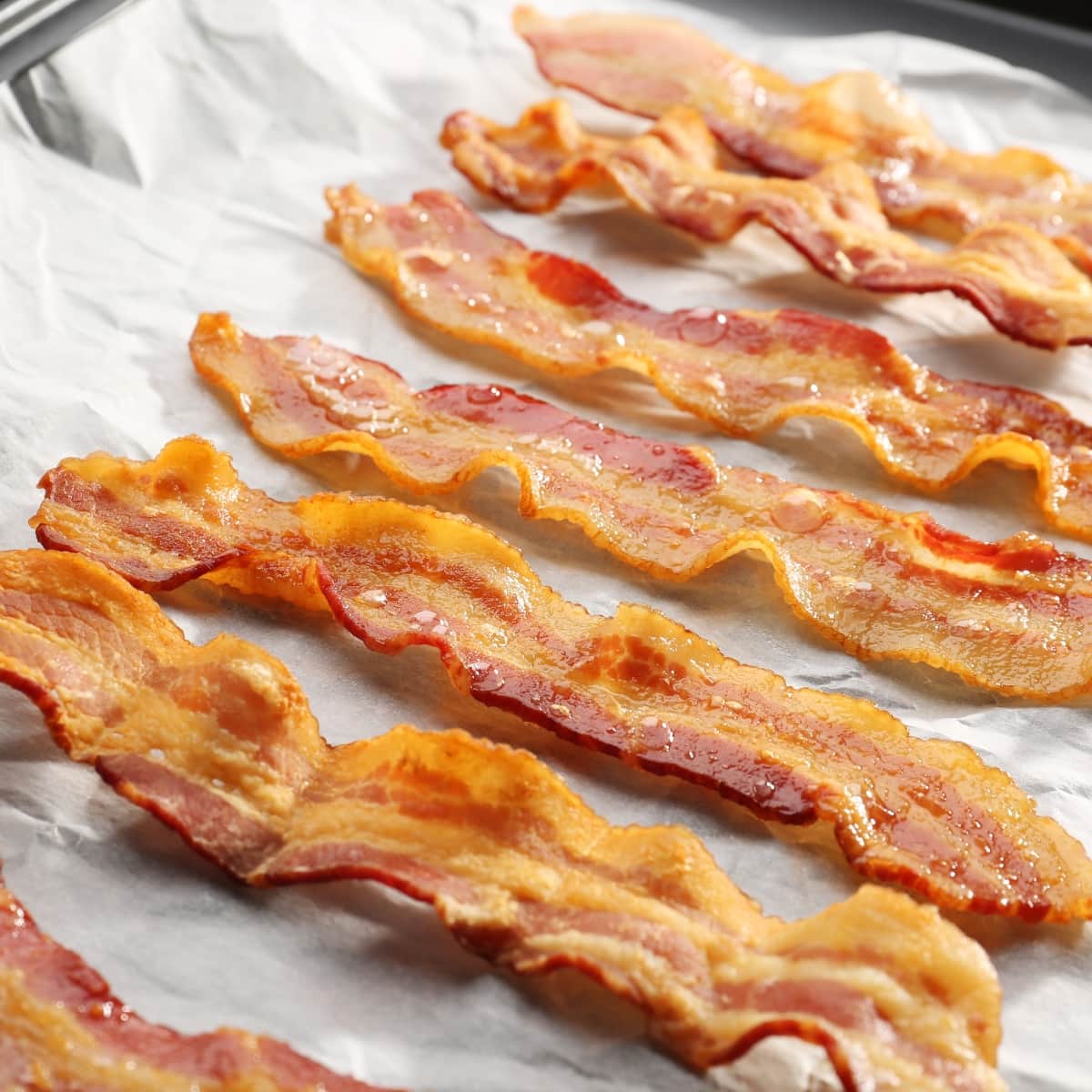 Baked Bacon Strips on Baking Sheet Laid on Parchment Paper 