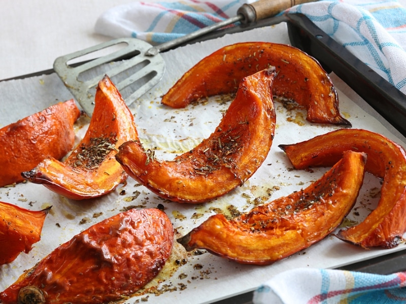 Roasted Acorn Squash Slices with Rosemary, Oil, and Seasonings on Parchement Paper