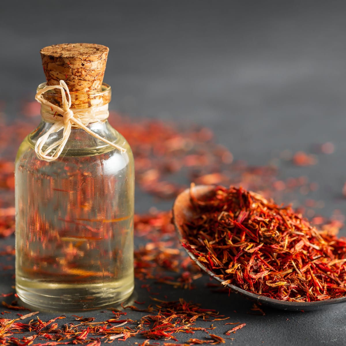 Bottle of Safflower Oil and Dried Safflower on a Spoon