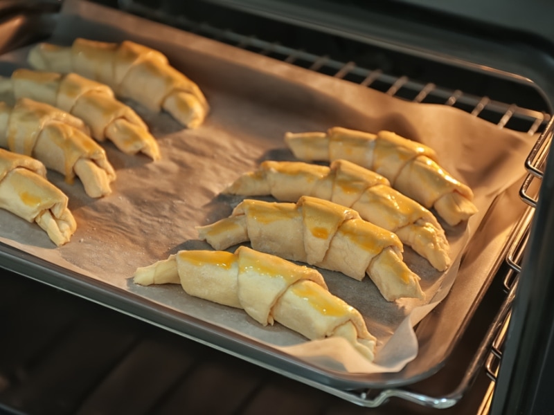 Crescent Rolls Cooking in Oven on Parchment Paper