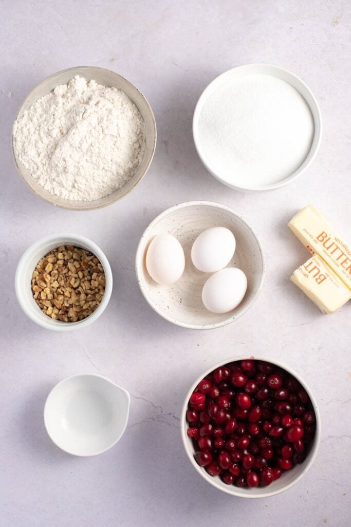 Cranberry Christmas Cake Ingredients - Eggs, Sugar, Butter, Almond Extract, Flour, Cranberries, Chopped Pecans and Whipped Cream
