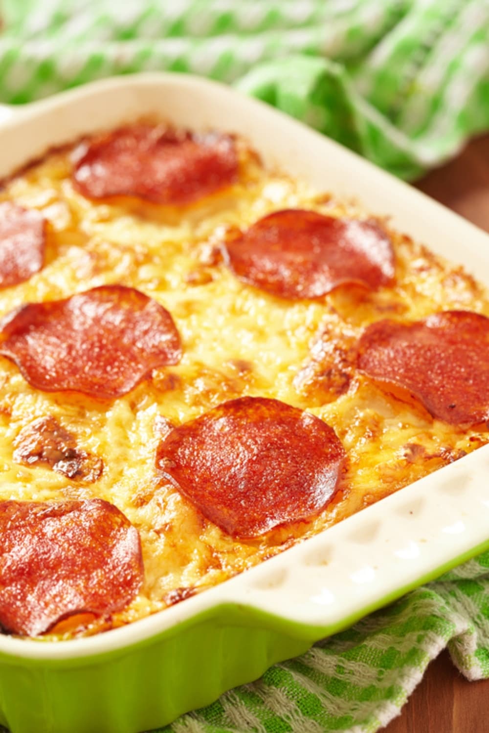 Pepperoni pizza casserole served on a green baking pan