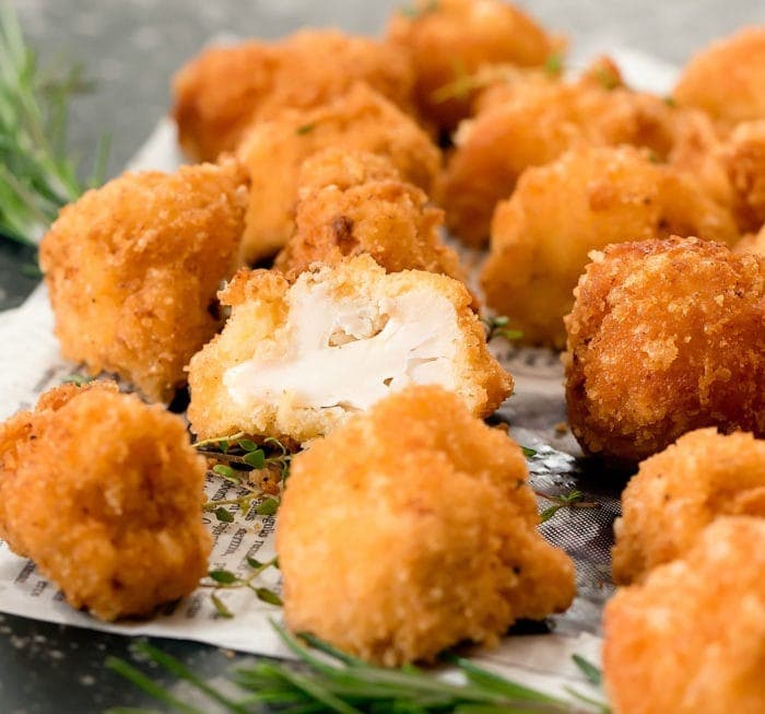 Breaded cauliflower bites on top of a piece of paper. 