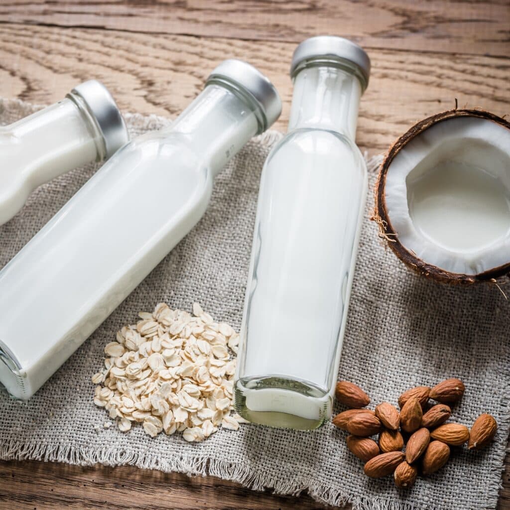 17 Different Types of Milk Explained featuring Different Types of Milk Including Coconut, Oat, and Almond Milk in Glass Jars