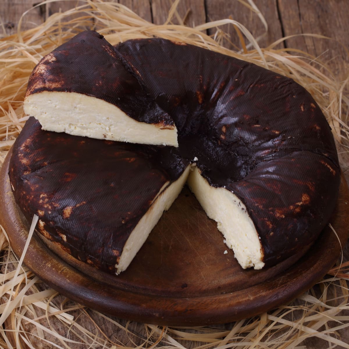 Whole Dry Jack Cheese Sliced on a Round Wooden Board