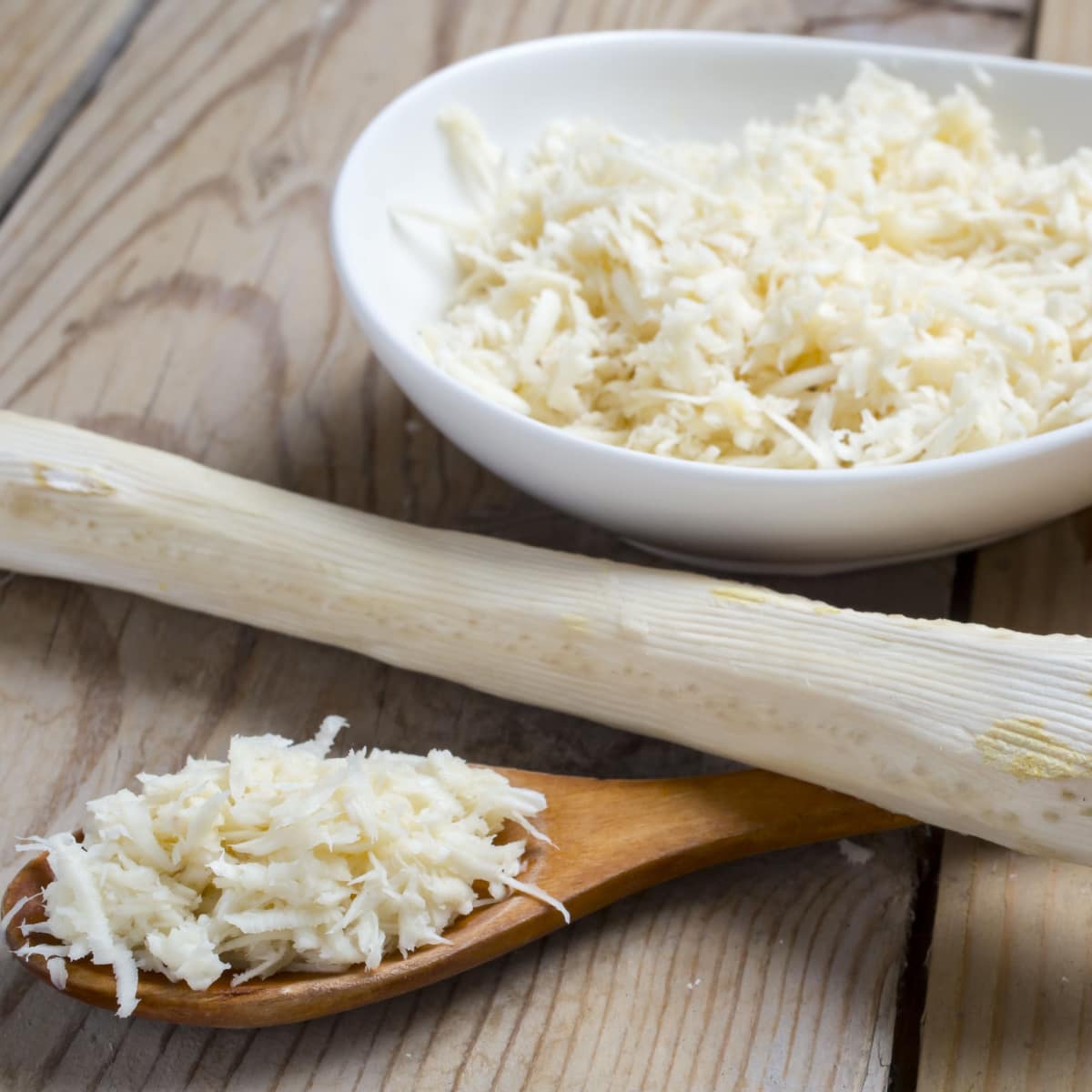 Grated Horseradish in a Bowl and Wooden Spoon