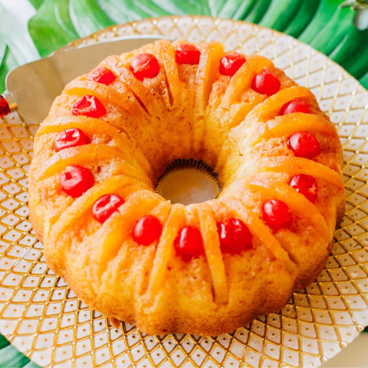 Homemade Pineapple Upside-Down Bundt Cake on a White and Gold-Patterned Serving Tray