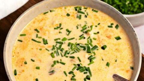 Homemade She Crab Soup Topped with Chives in a Wooden Board