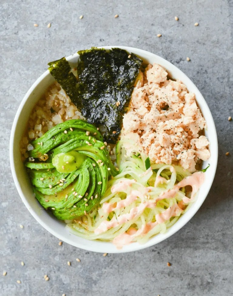 Salmon sushi bowl with seaweeds, avocado and cucumber. 