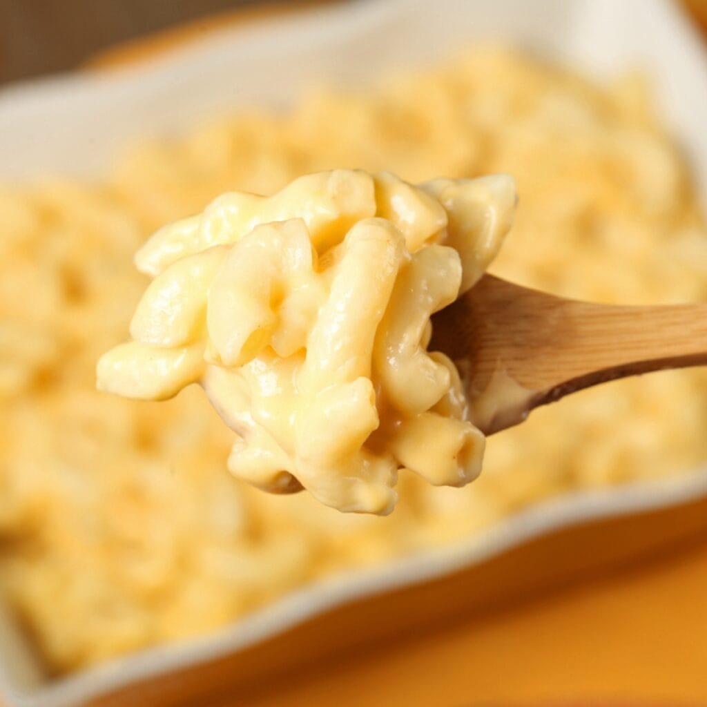 Wooden Spoon Scooping Mac and Cheese on a Pan