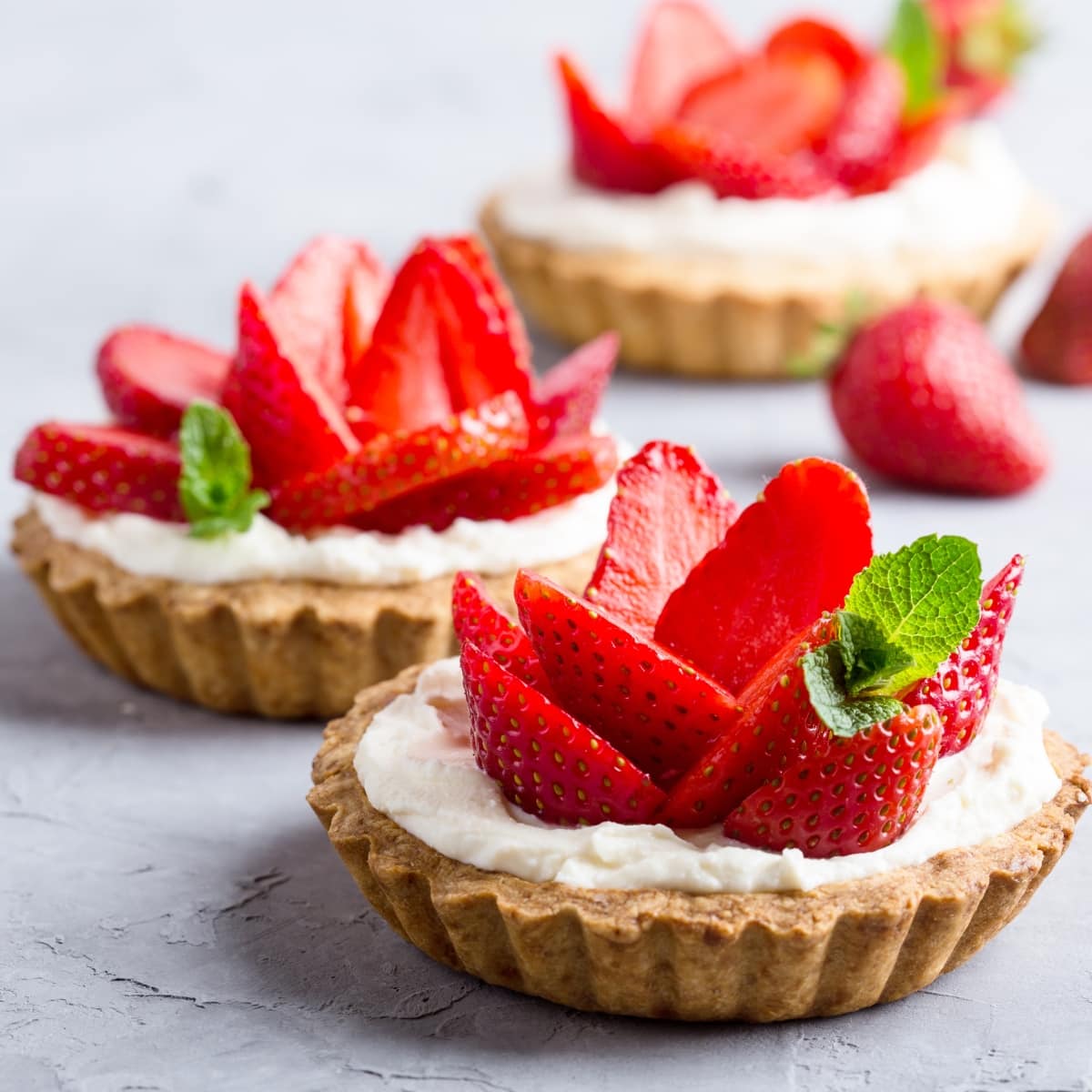 Mini Strawberry Tarts with Cream and A Sprig of Mint