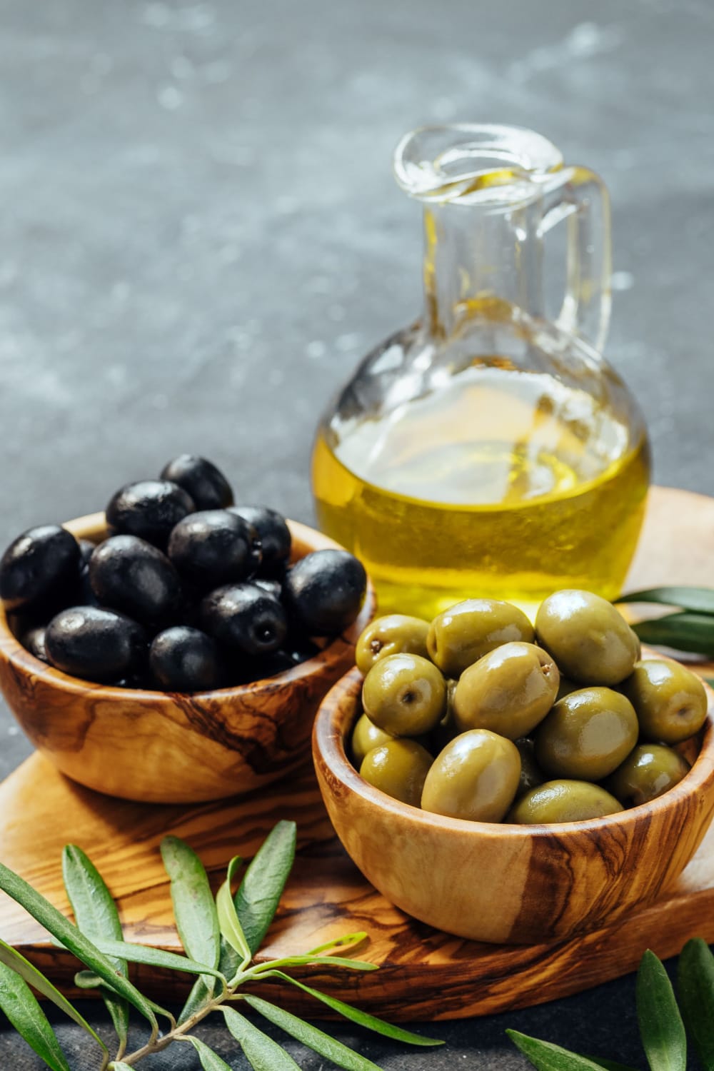 Bowl of Black and Green Olives and Olive Oil on a Bottle