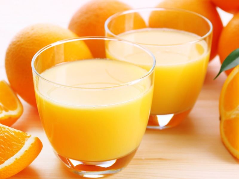 Two Glasses of Freshly Squeeze Orange Juice and Oranges on a Wooden Table