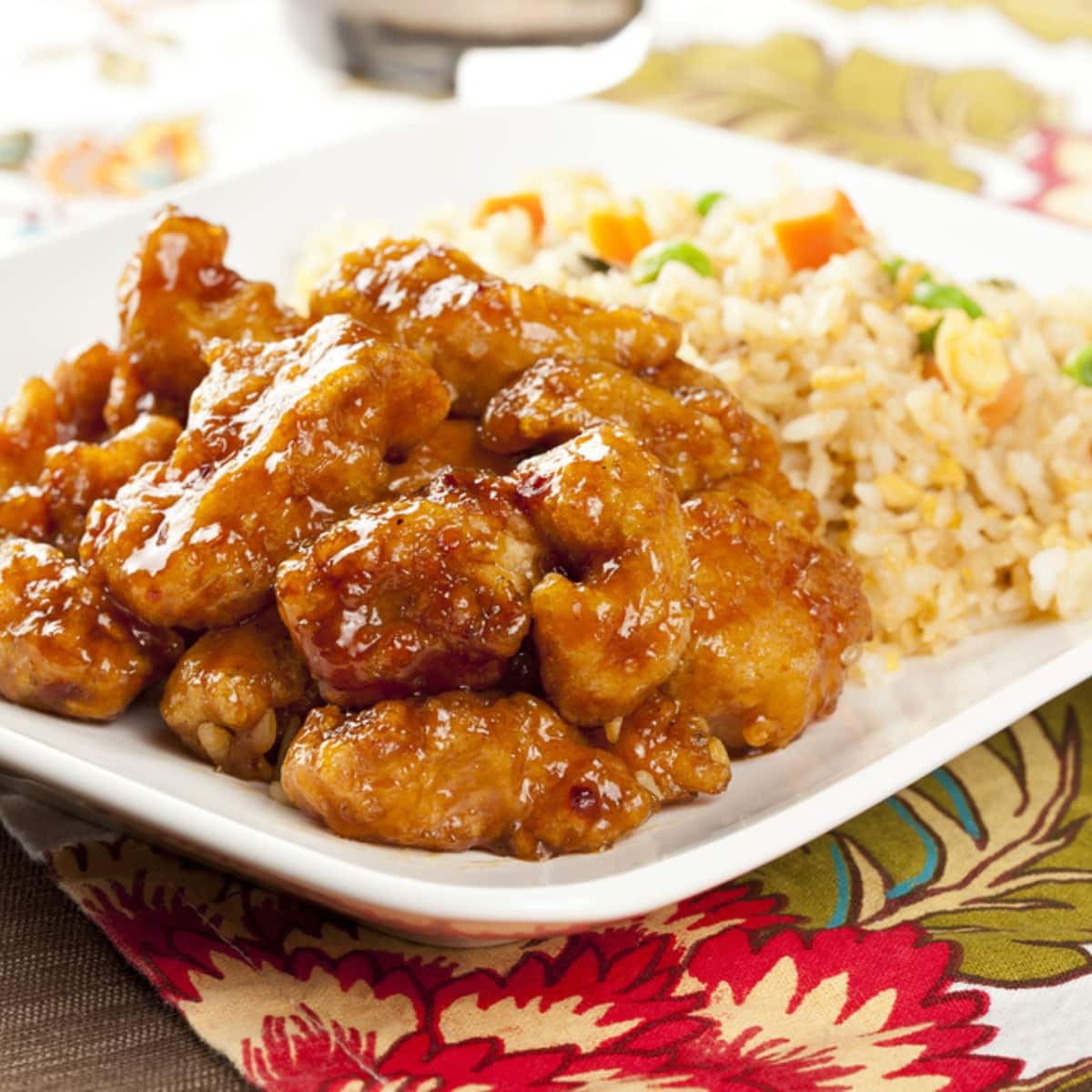 A plate of Orange Chicken served with fried rice 