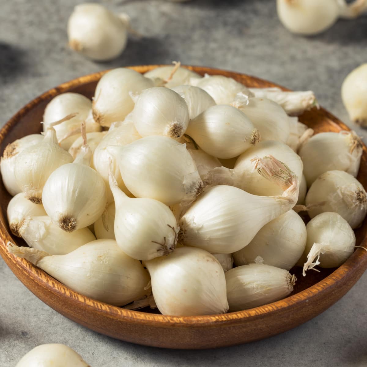 Raw White Organic Pearl Onions in a Bunch on a Wooden Bowl