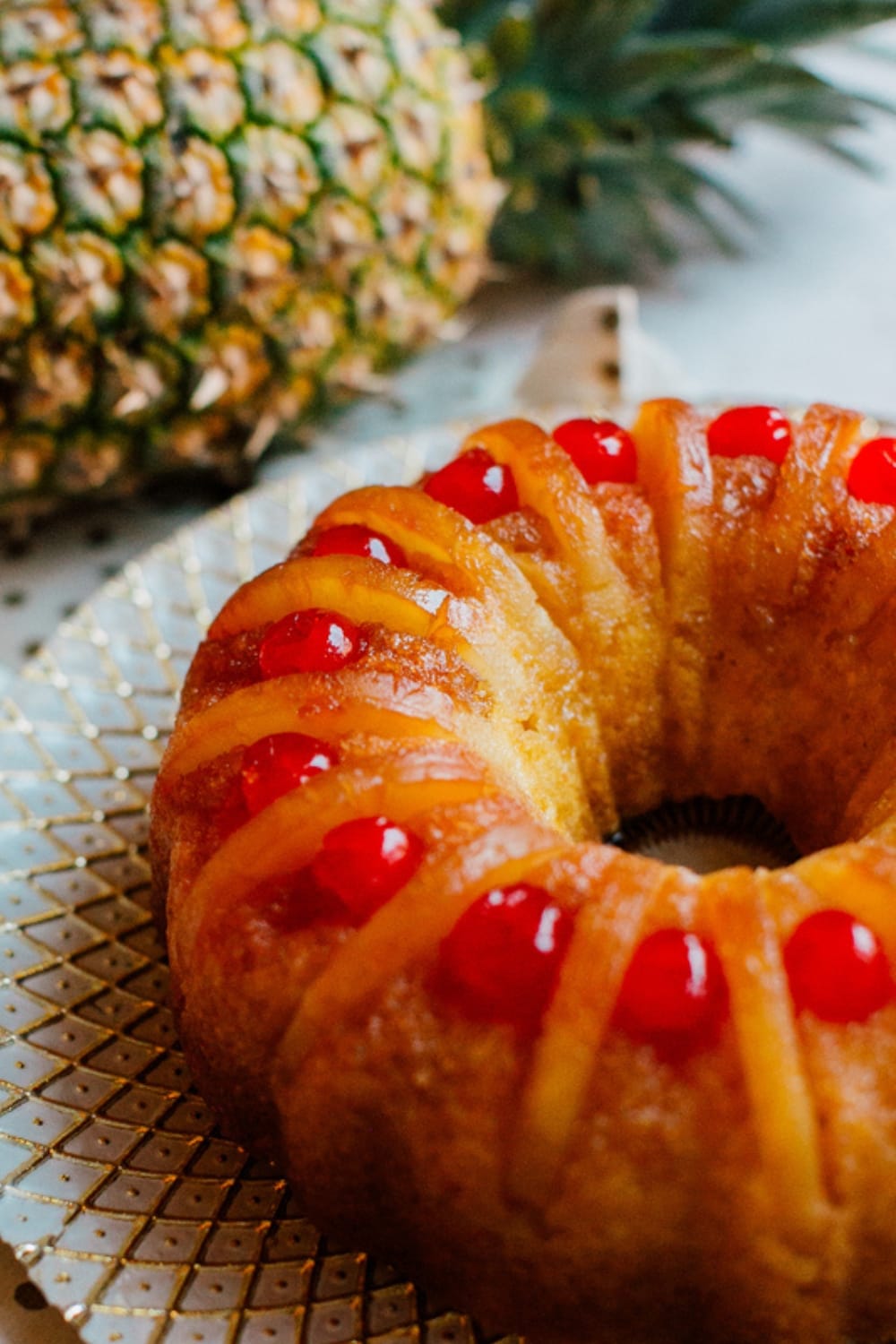 Pineapple Upside-Down Bundt Cake Closeup with Pineapple in the Background