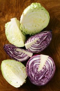 Raw Organic Red and Green Cabbage on a Wooden Background