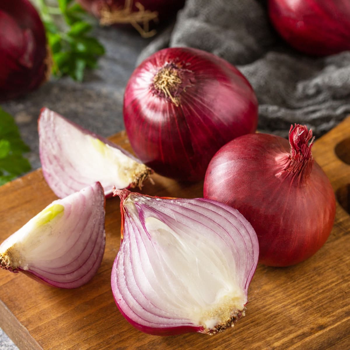 Whole and Slice Red Onions on a Wooden Cutting Board