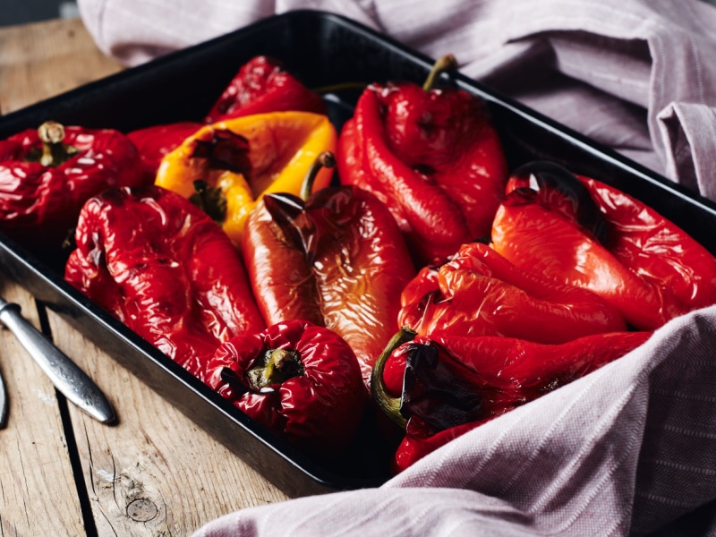 Roasted Red and Yellow Peppers in Baking Tray on a Wooden Table