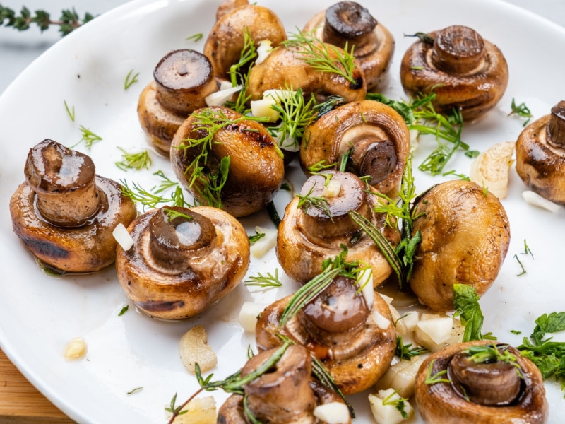 Yummy Roasted Mushrooms with Garlic and Herbs in a White Plate